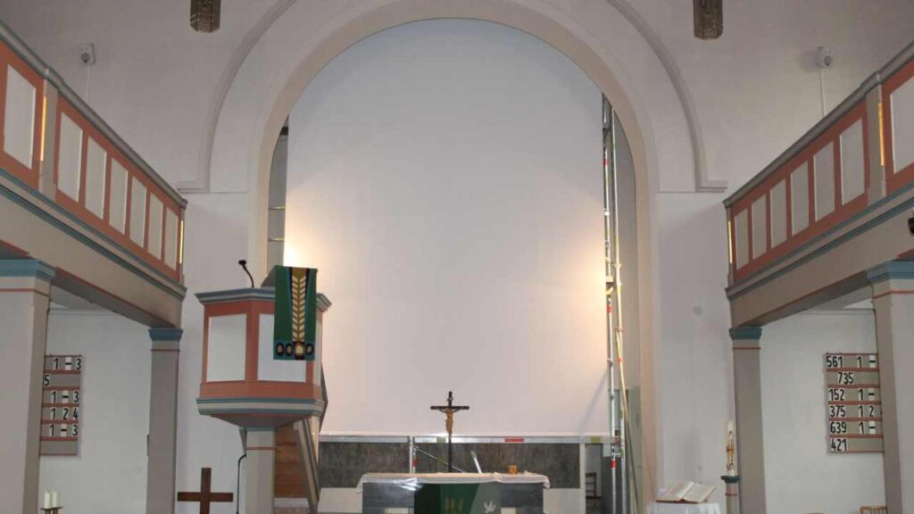 Motorleinwand in historischer Kirche installiert – dezente Medientechnik für sakrale Räume